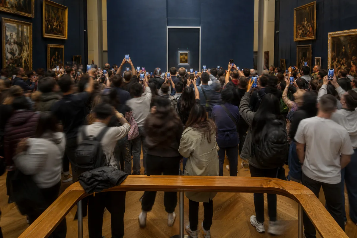 Foule de visiteurs dans une salle de musée devant un tableau protégé