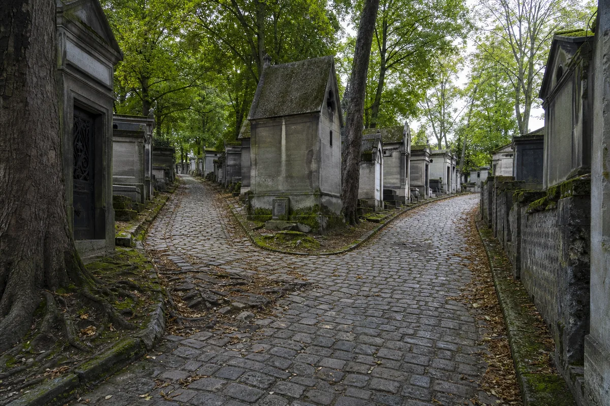 Allée pavée bordée de sépultures anciennes et d arbres au cimetière du Père-Lachaise